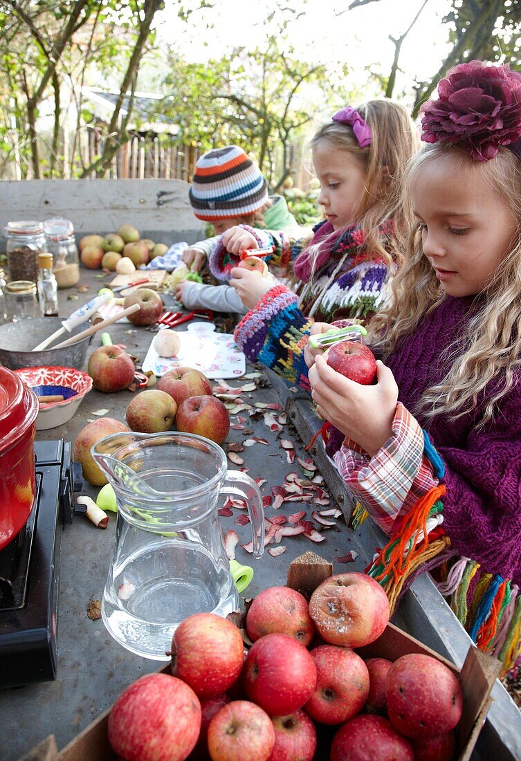 Kinder schälen Äpfel