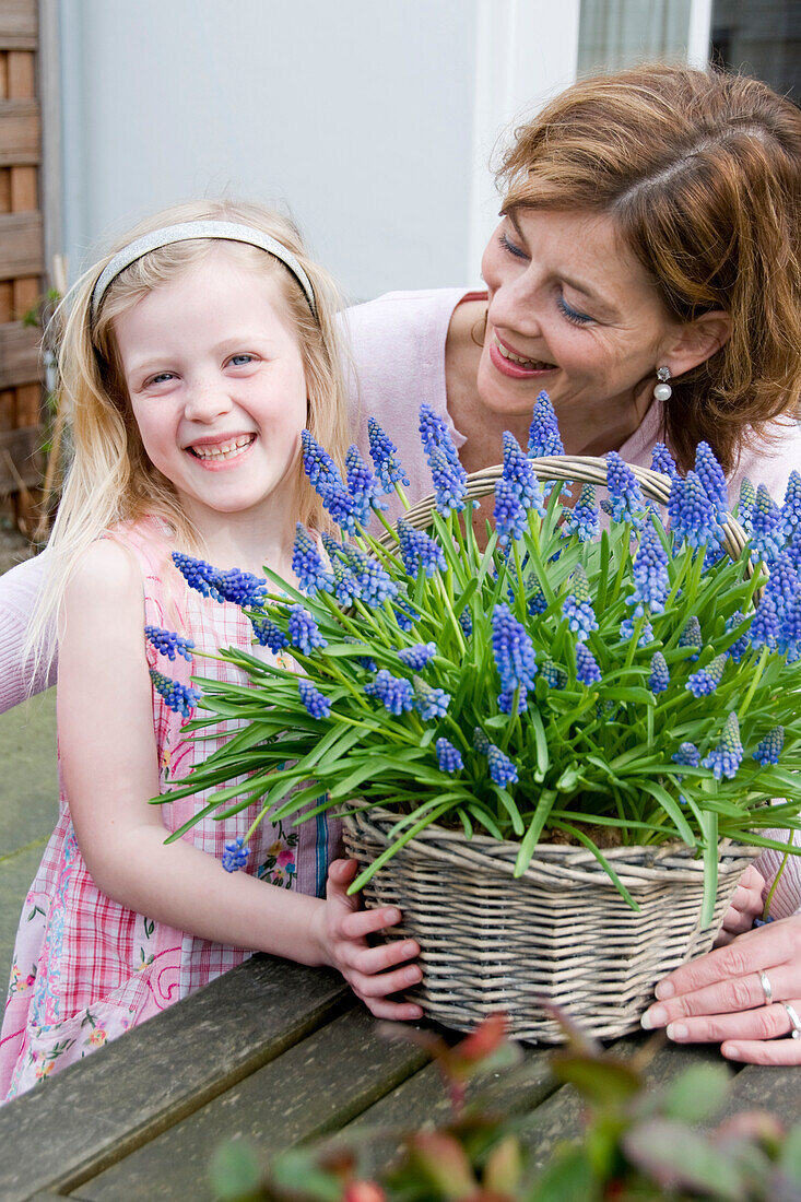 Mutter und Tochter mit Muscari in der Hand