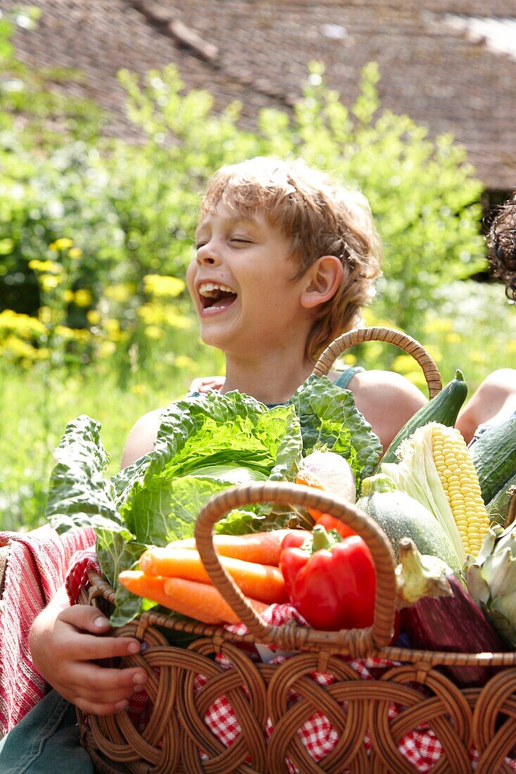 Boy holding basket with vegetables