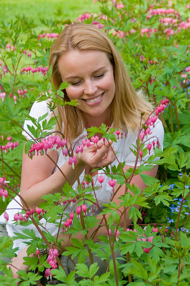 Woman touching Dicentra spectabilis