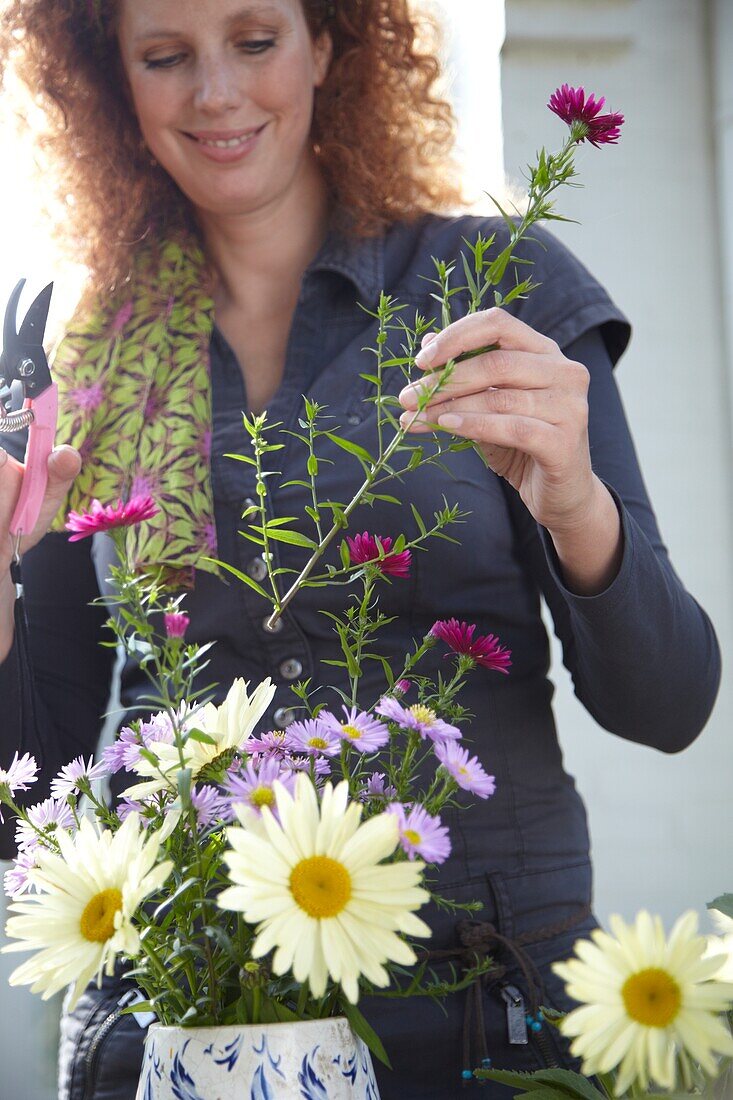 Frau arrangiert Herbstblumen