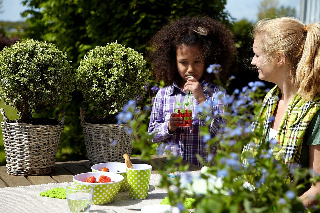 Mutter und Tochter am Gartentisch