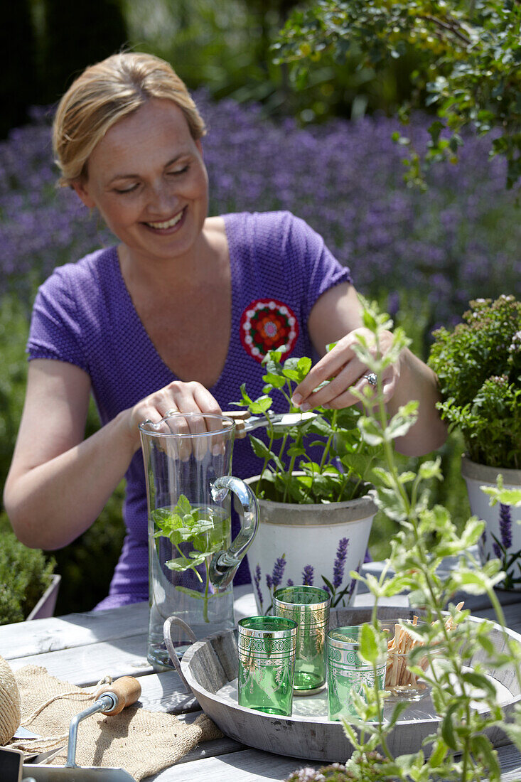 Frau bei der Gartenarbeit mit Kräutern