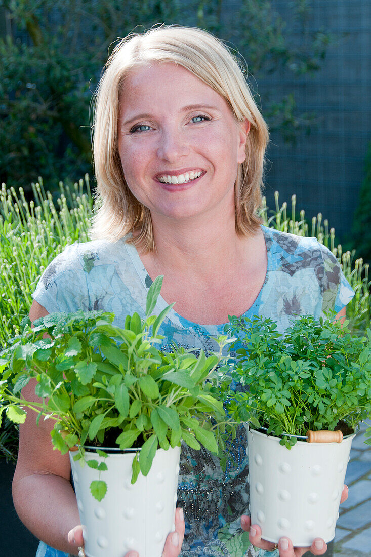 Frau mit Kräutern in der Hand