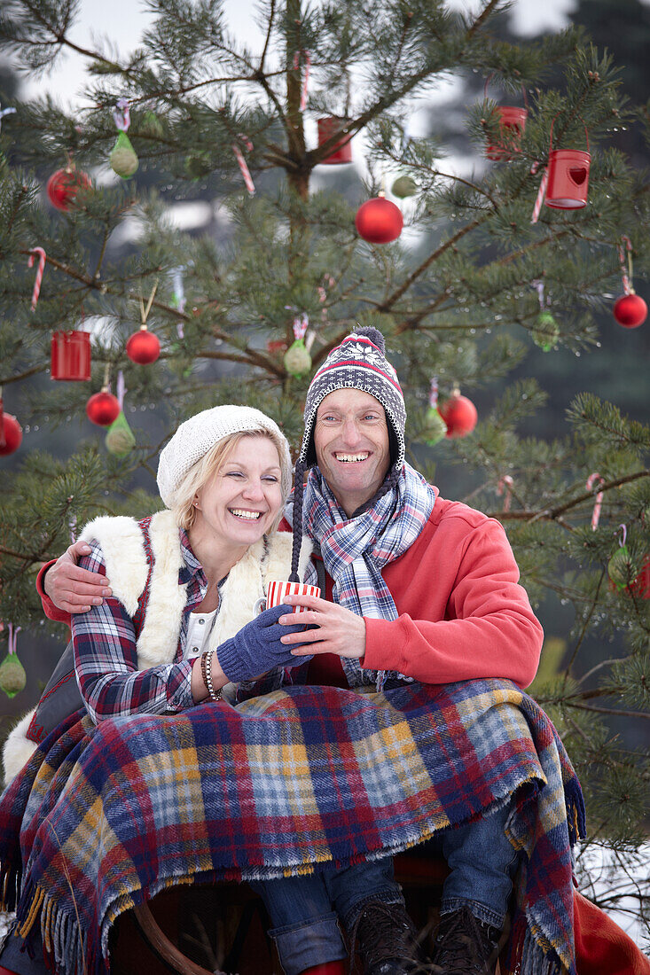 Couple sitting under christmas tree