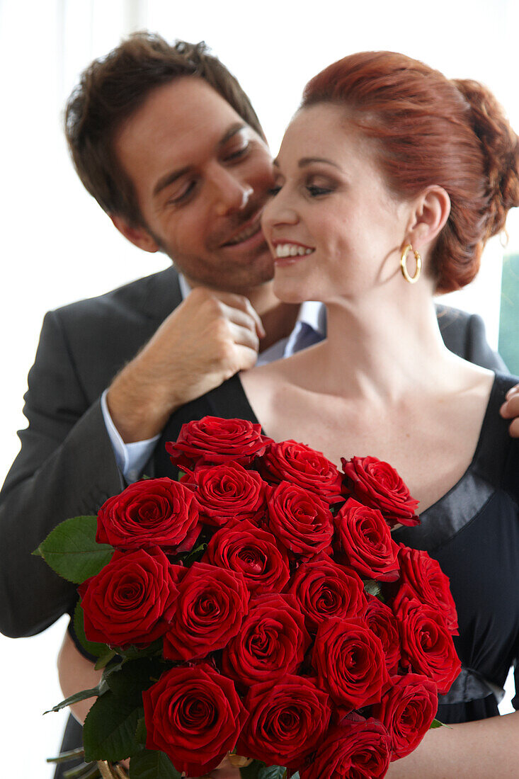 Paar mit roten Rosen in der Hand
