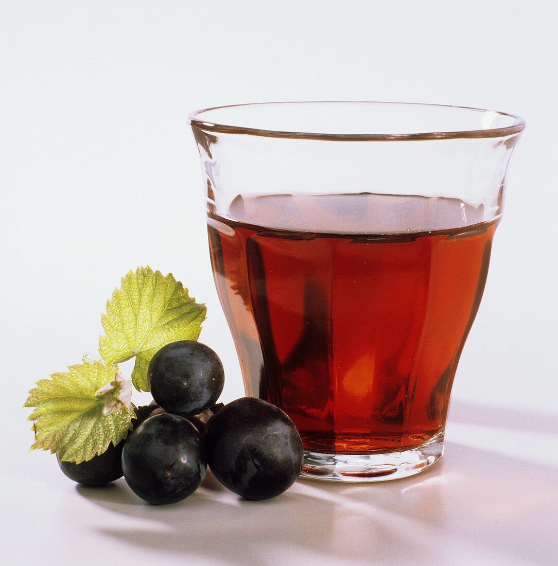 Red grape juice in glass; decoration: red grapes