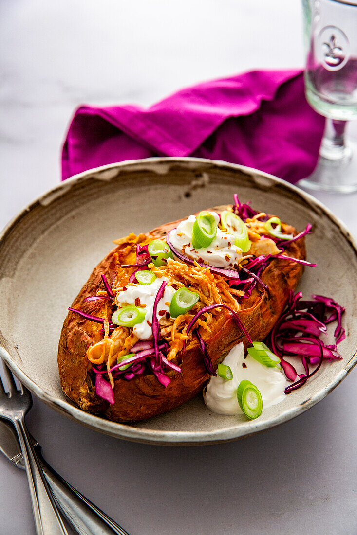 Sweet potato with pulled chicken, coleslaw and sour cream
