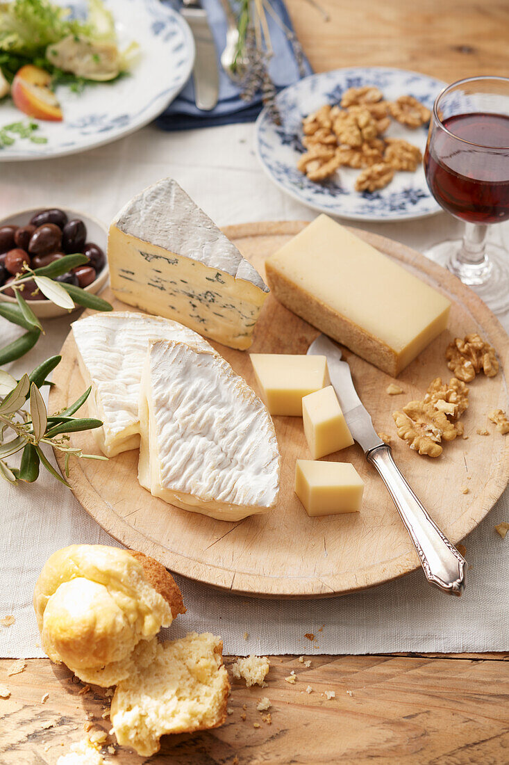 French cheese platter with red wine, olives and walnuts