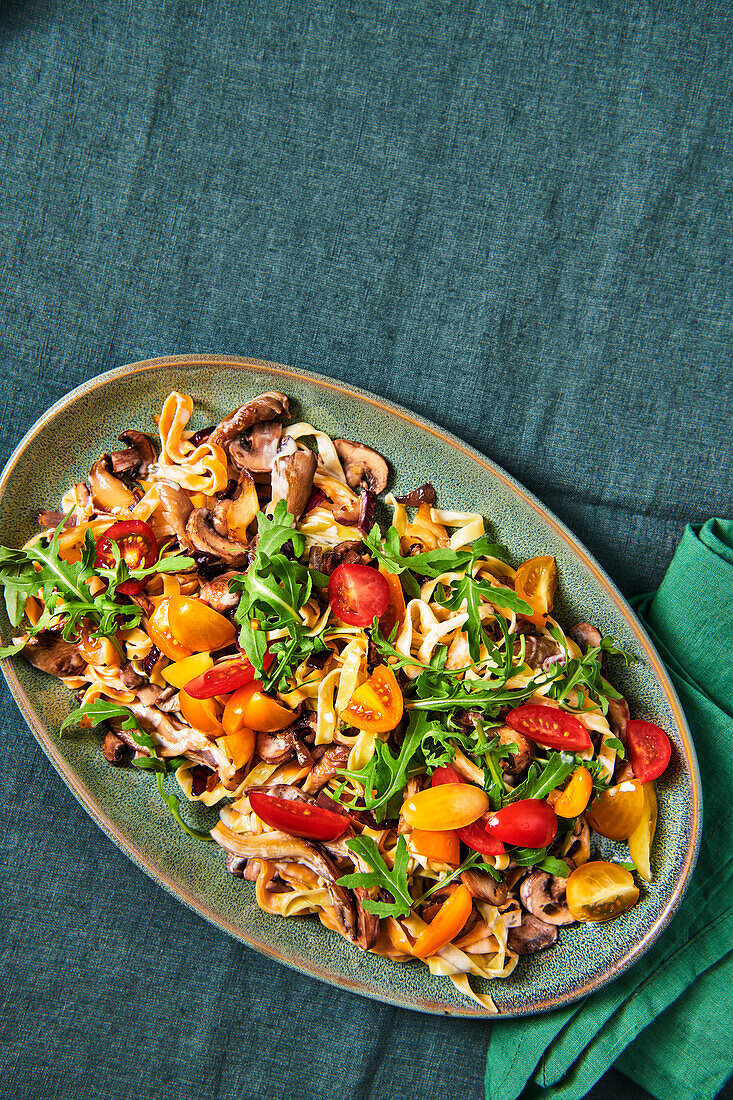Ribbon noodles with mushrooms, rocket and tomatoes
