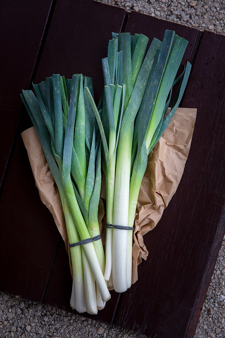 Two bunches of leek on a paper bag