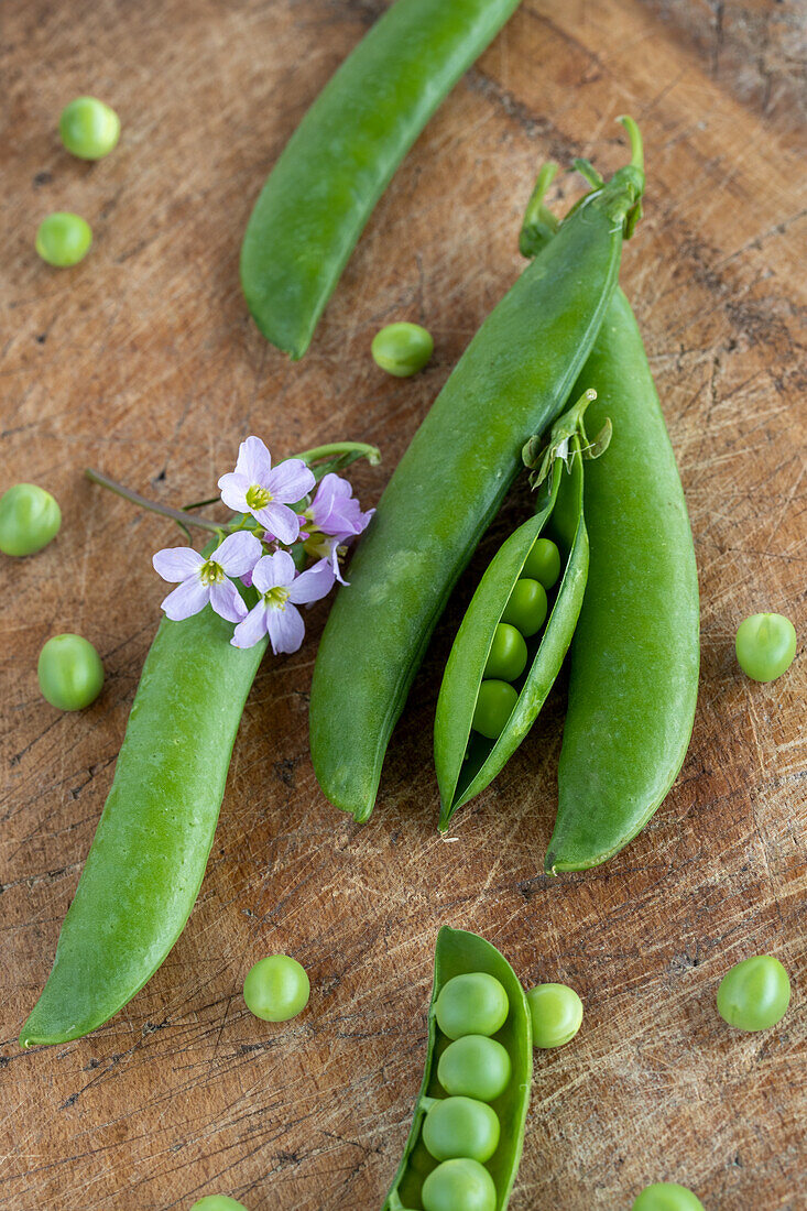 Fresh peas and pods on wooden surface