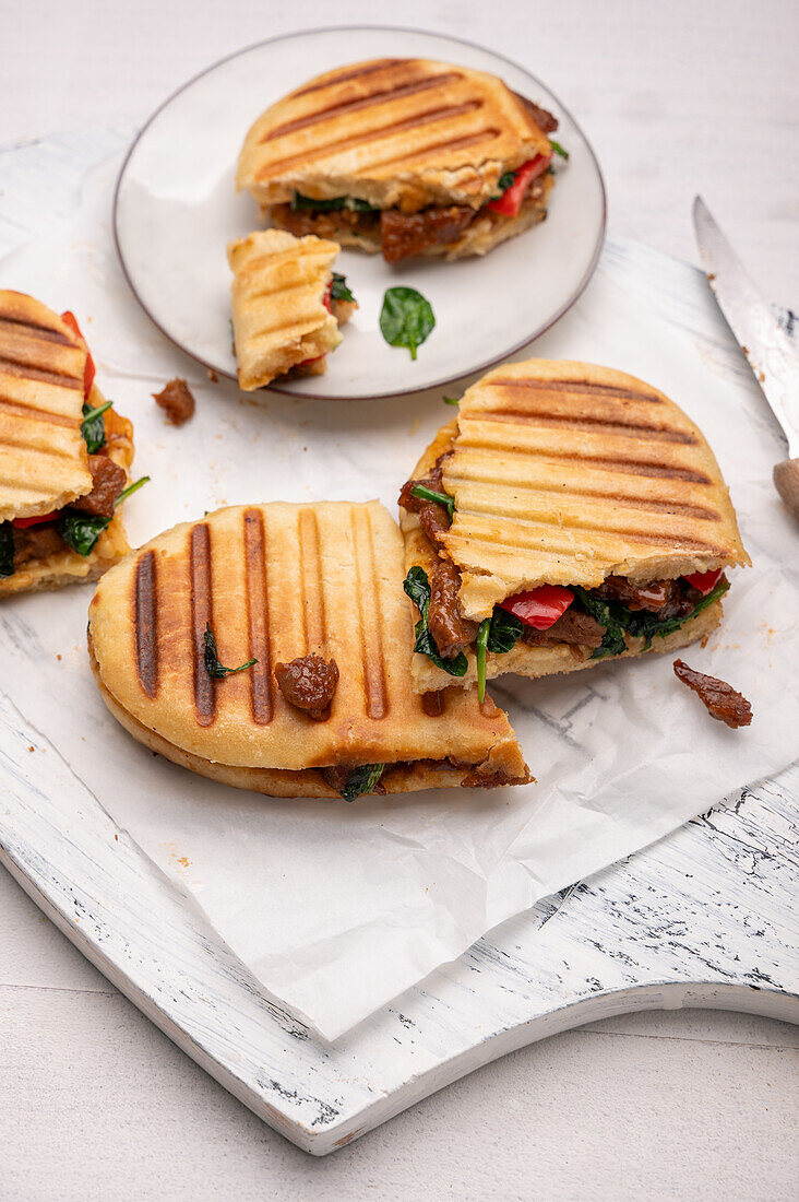 Veganes gegrilltes Panini-Sandwich mit Sojaschnetzeln, Spinat und Paprika