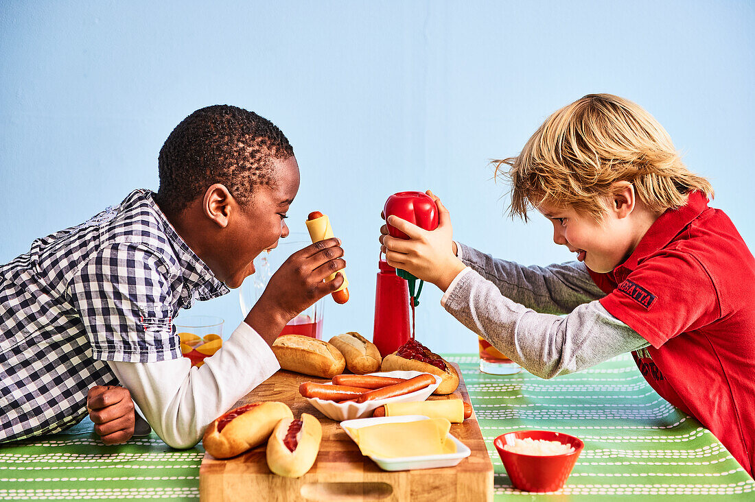 Two boys prepare hot dogs