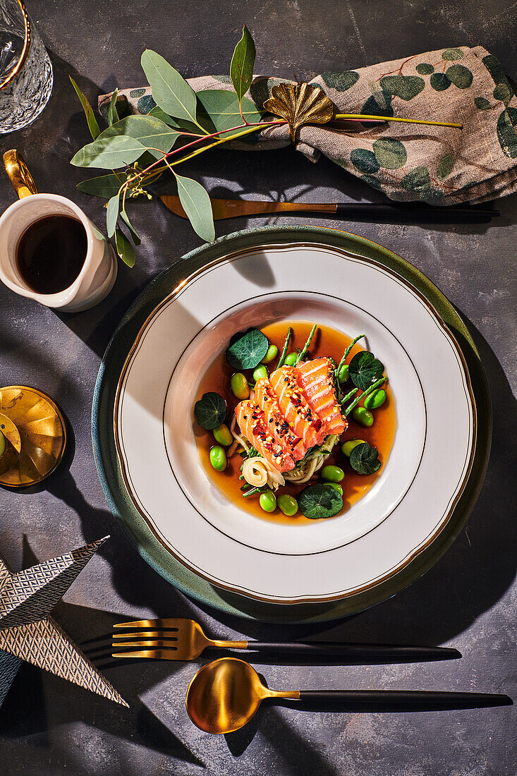 Salmon sashimi in miso broth with courgette, edamame and ginger