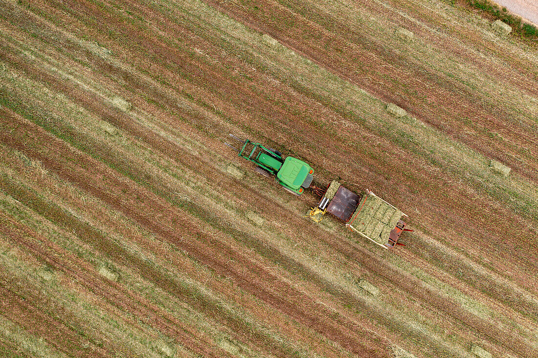 Aerial view of tractor collecting hay bales