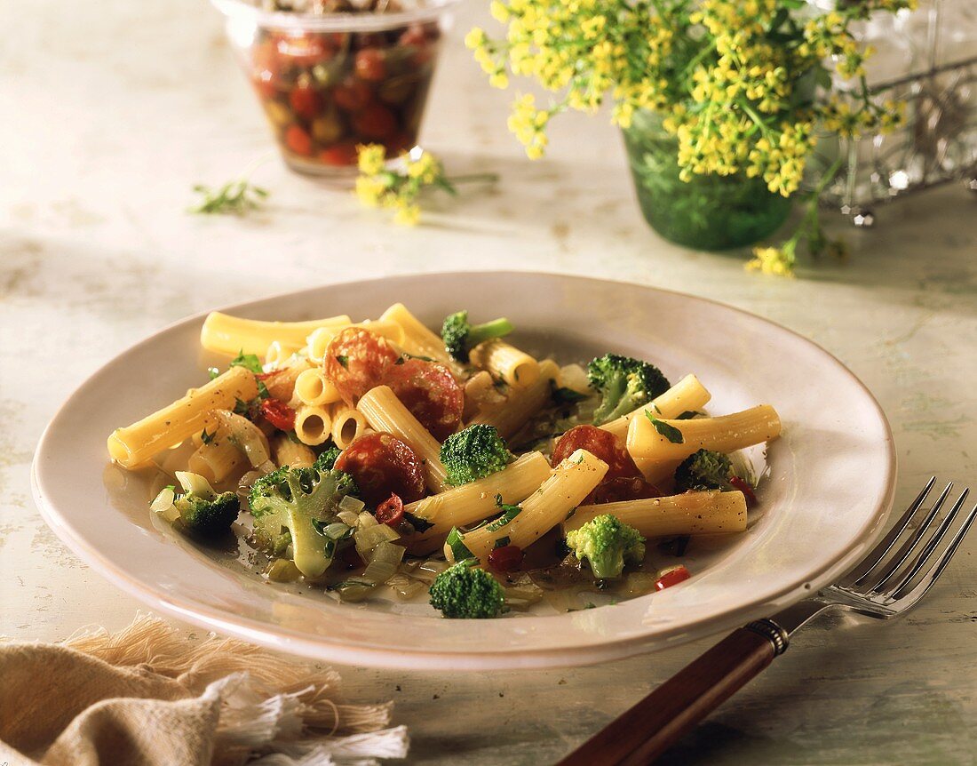 Rigatoni with broccoli & salami slices on plate