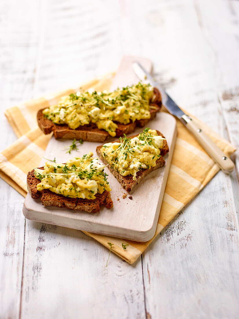 Scrambled eggs with herbs and feta on toasted bread