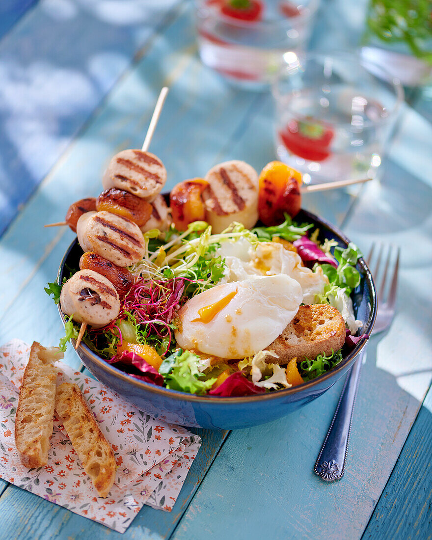 Skewers with boudin blanc and apricots on salad with egg