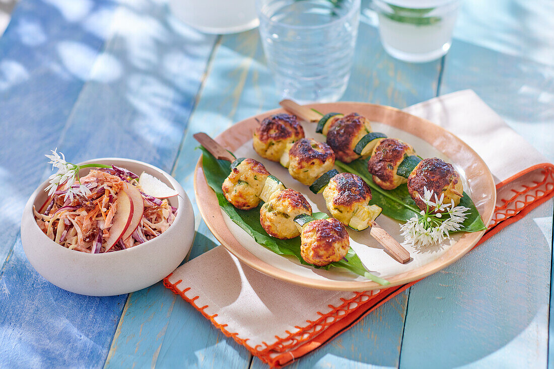 Grilled chicken meatballs on skewers with coleslaw
