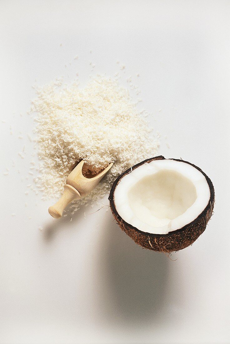Coconut half and grated coconut with wooden scoop