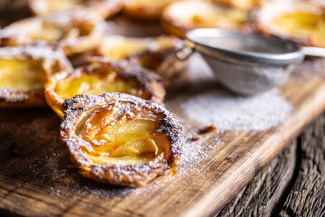 Mini tarts made of puff pastry and sliced apples sprinkled with powdered sugar