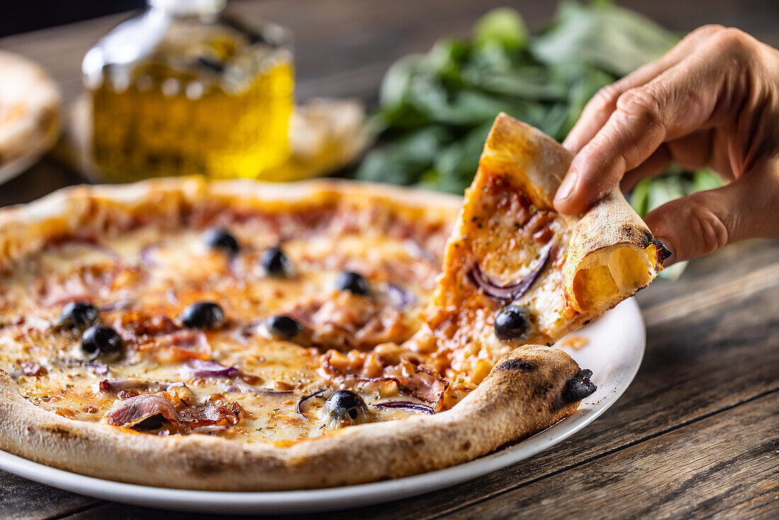Pizza with bacon, onions and black olives
