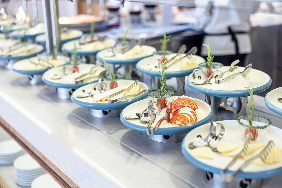 Plate of cheese, tomatoes and herbs at the buffet in a hotel restaurant