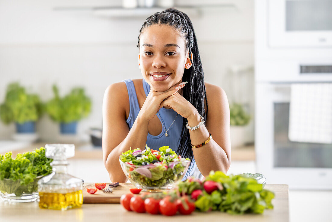 Junge Afroamerikanerin bereitet gesunden Salat zu