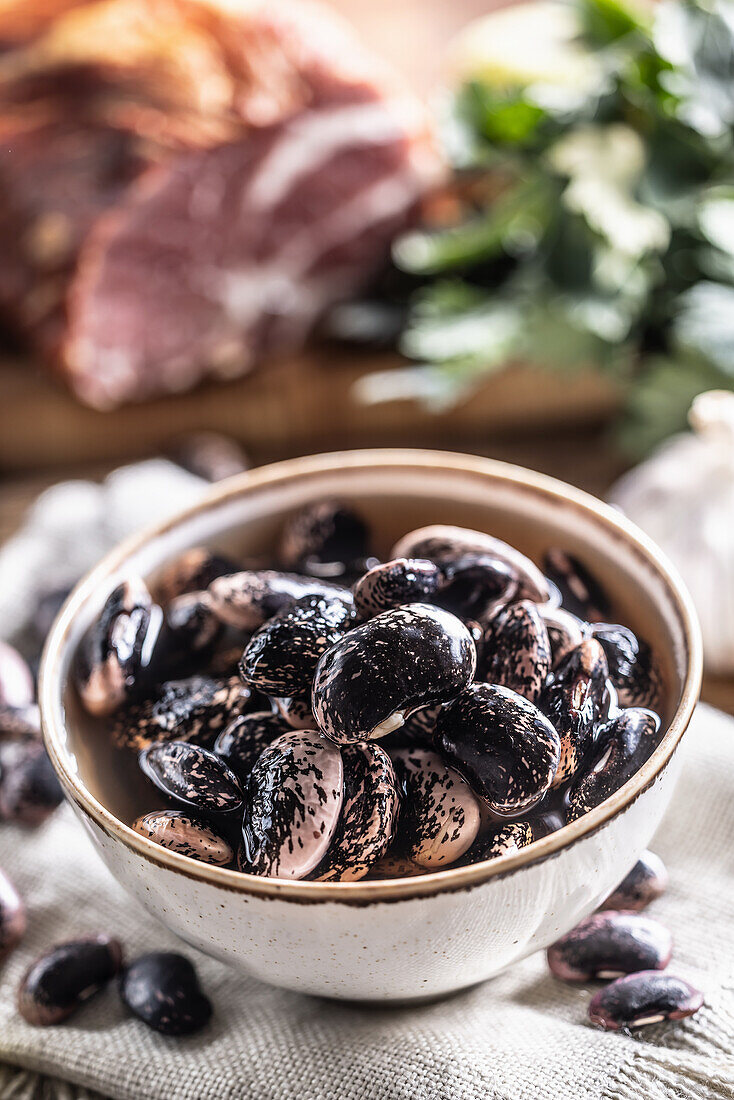 Beetle beans in a bowl and smoked pork neck in the background