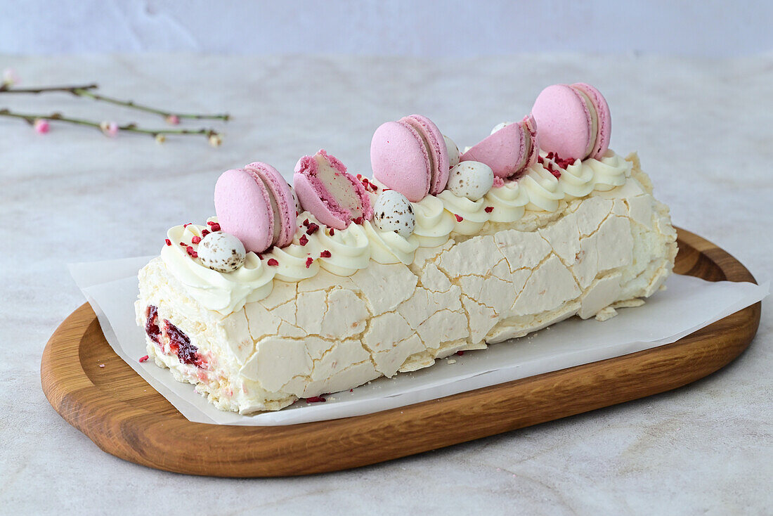 Meringue coconut roll with cherries decorated with macarons for Easter
