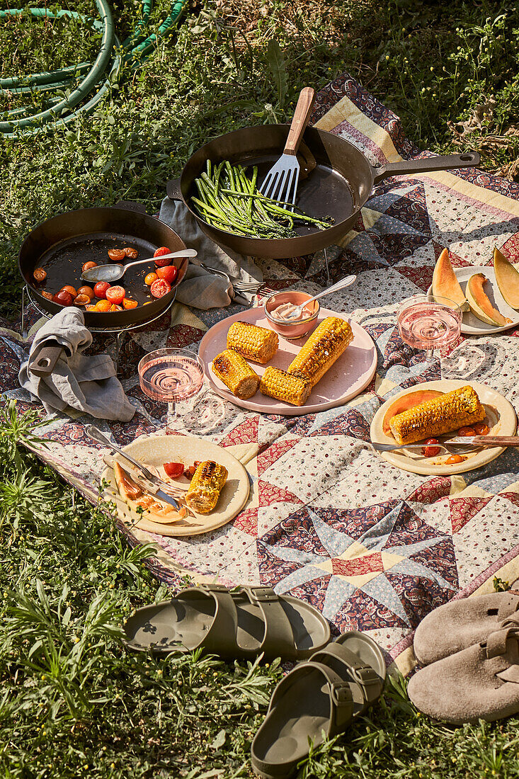 Picknick mit gerösteten Tomaten, grünem Spargel und gegrilltem Mais