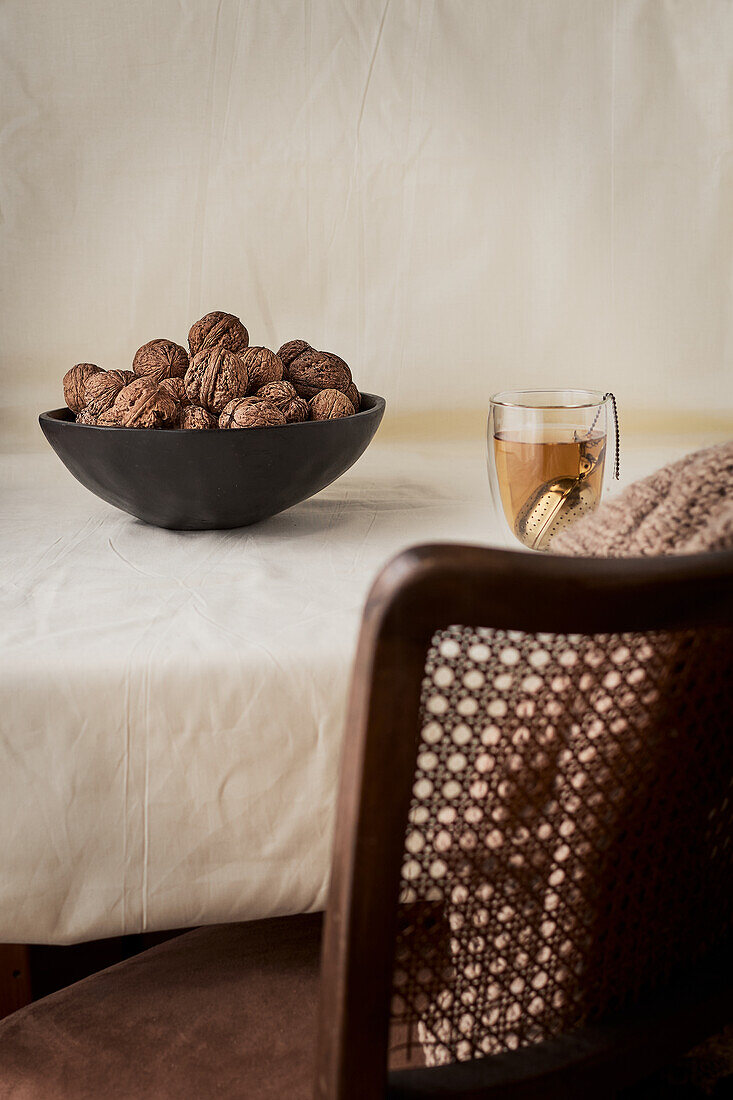Black bowl of whole walnuts on a table
