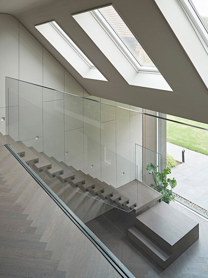 Blick vom Obergeschoss in den Eingangsbereich, Treppe mit Glasgeländer