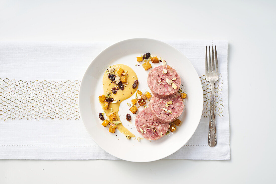 Cotechino with pumpkin cream and dried fruit