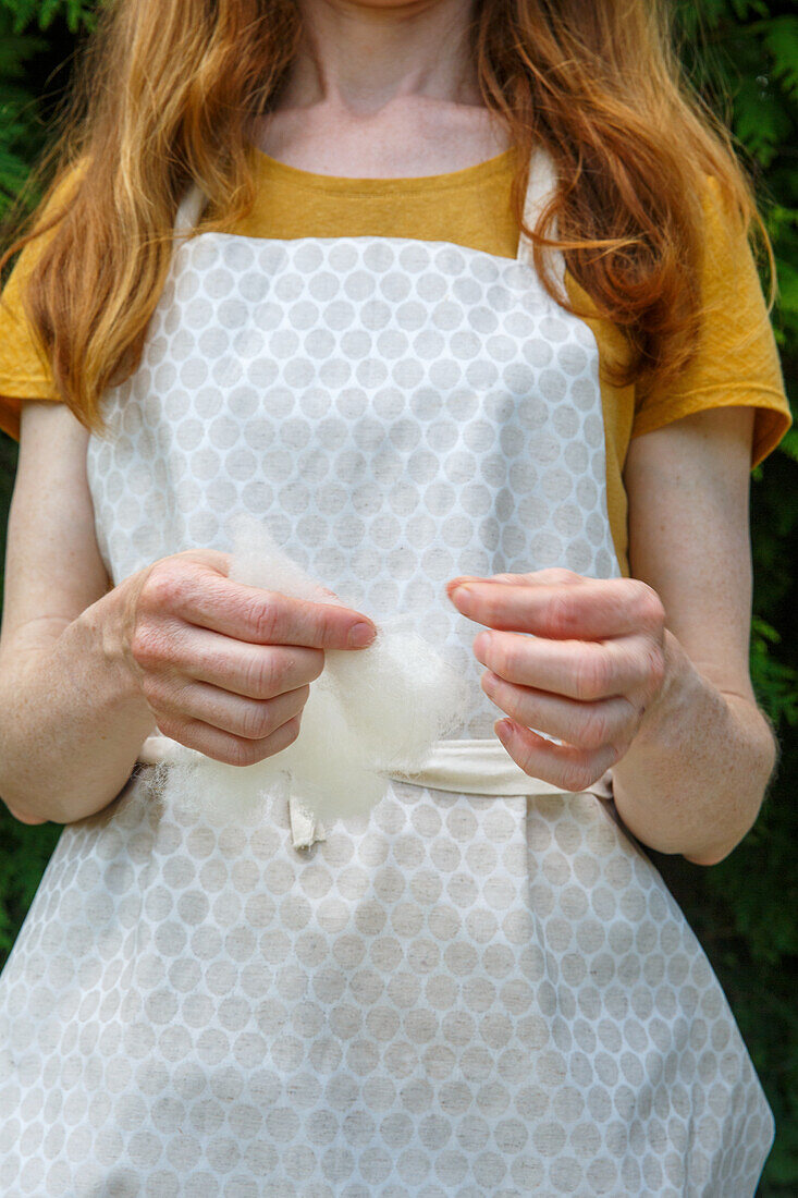 Person with apron holding felt in their hands