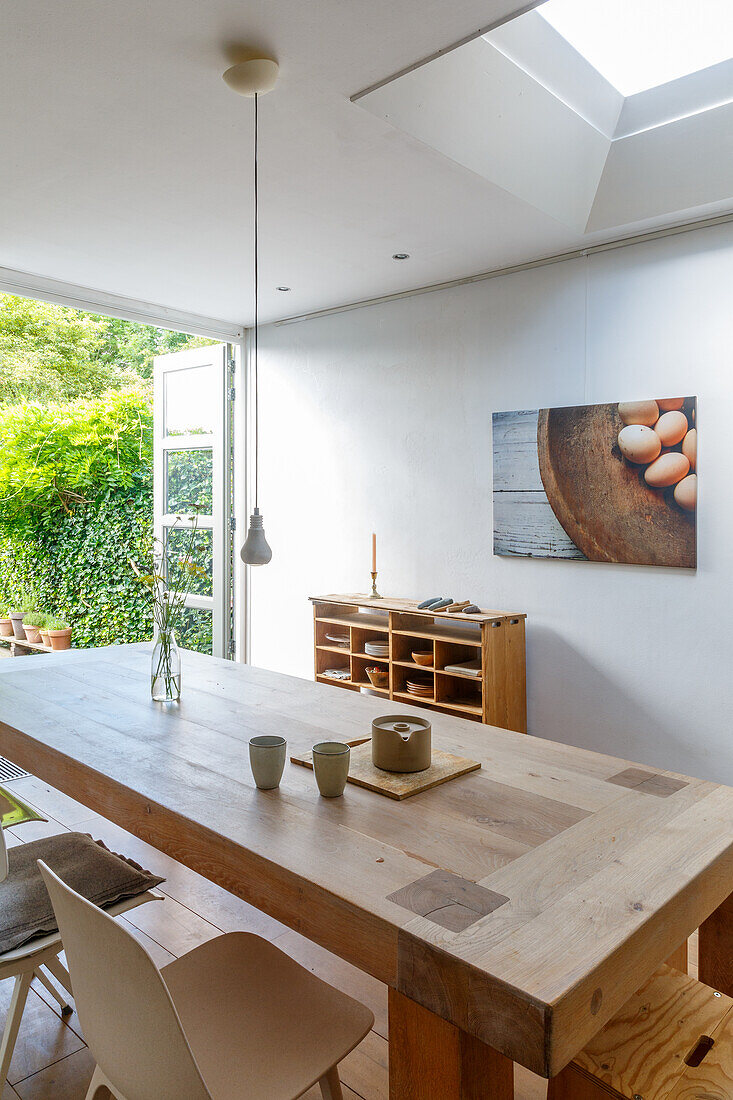 Dining area with wooden table, chairs and skylight