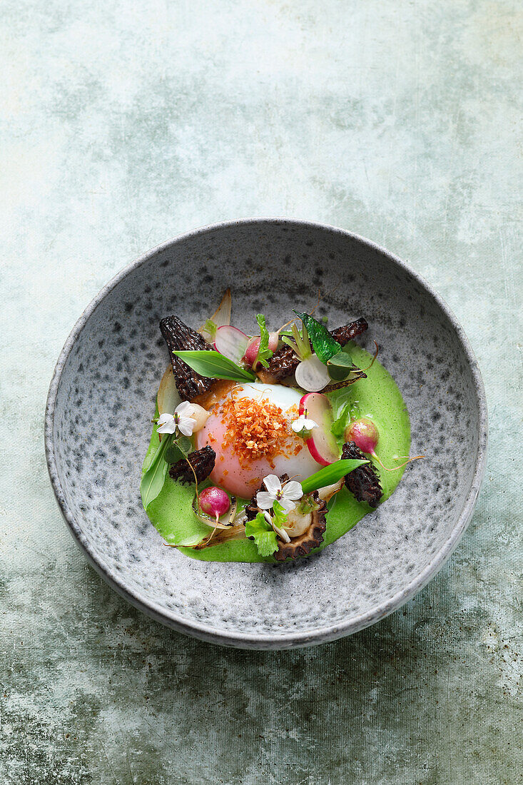 Onsen egg in wild garlic jus with morels and roasted onions