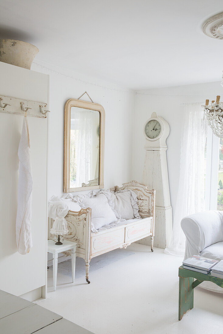 Bright living room in shabby chic style with antique furniture and grandfather clock