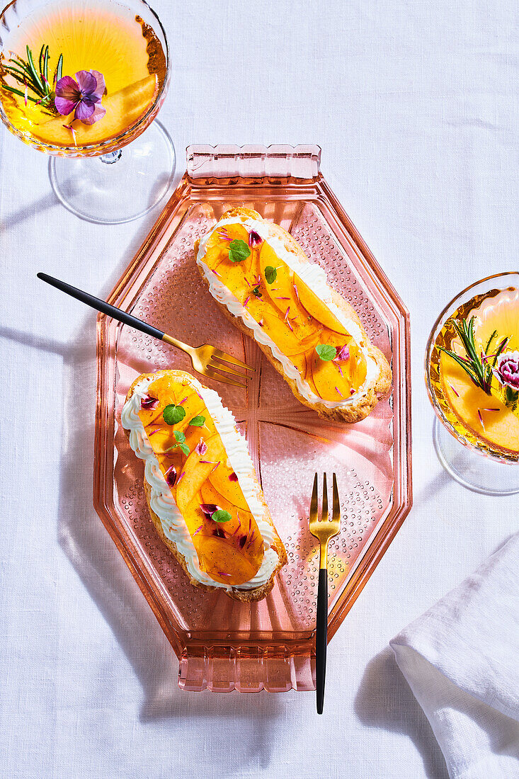 Open peach eclairs served with a French 75