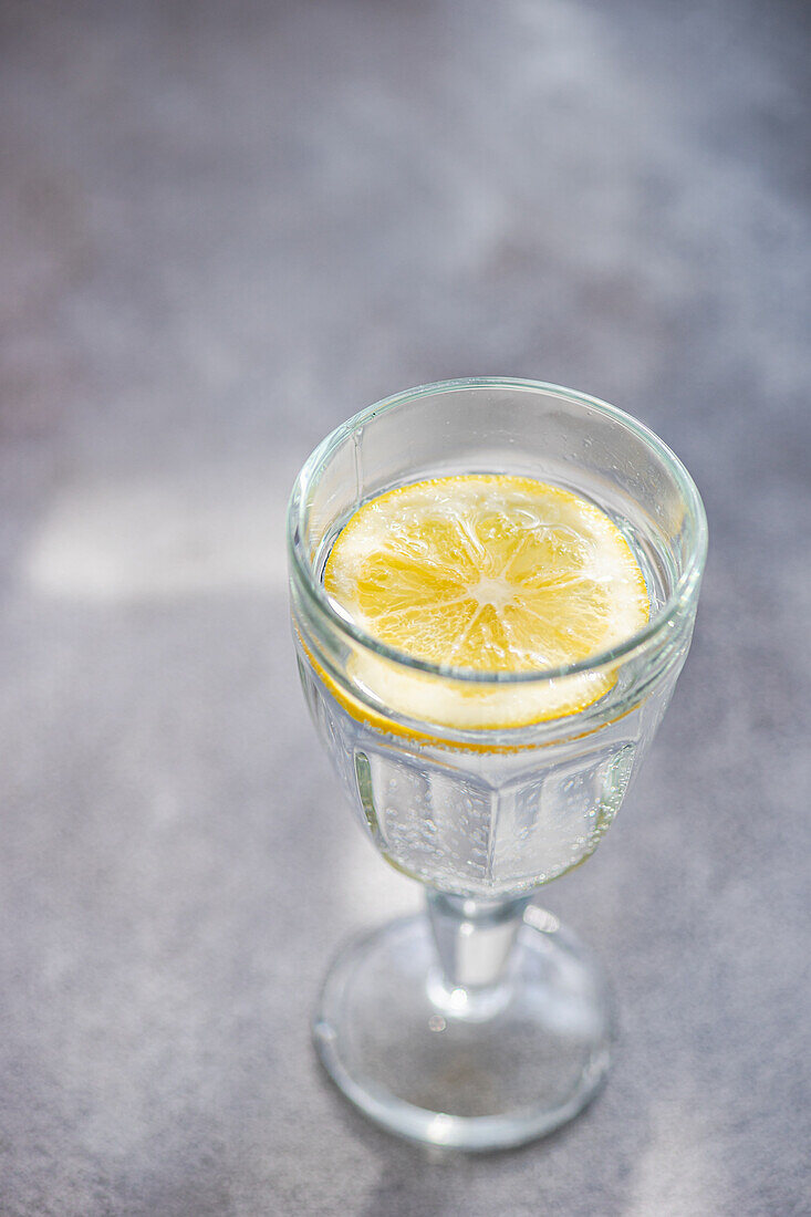 Glas mit Wasser und Zitronenscheibe