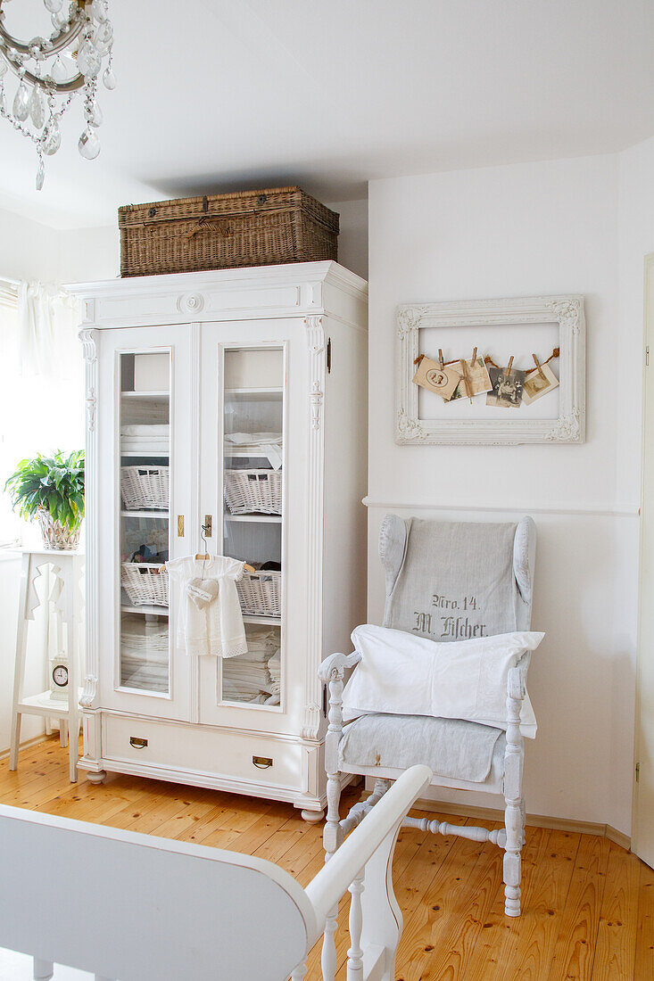 White country-style wardrobe and rustic armchair in the living room