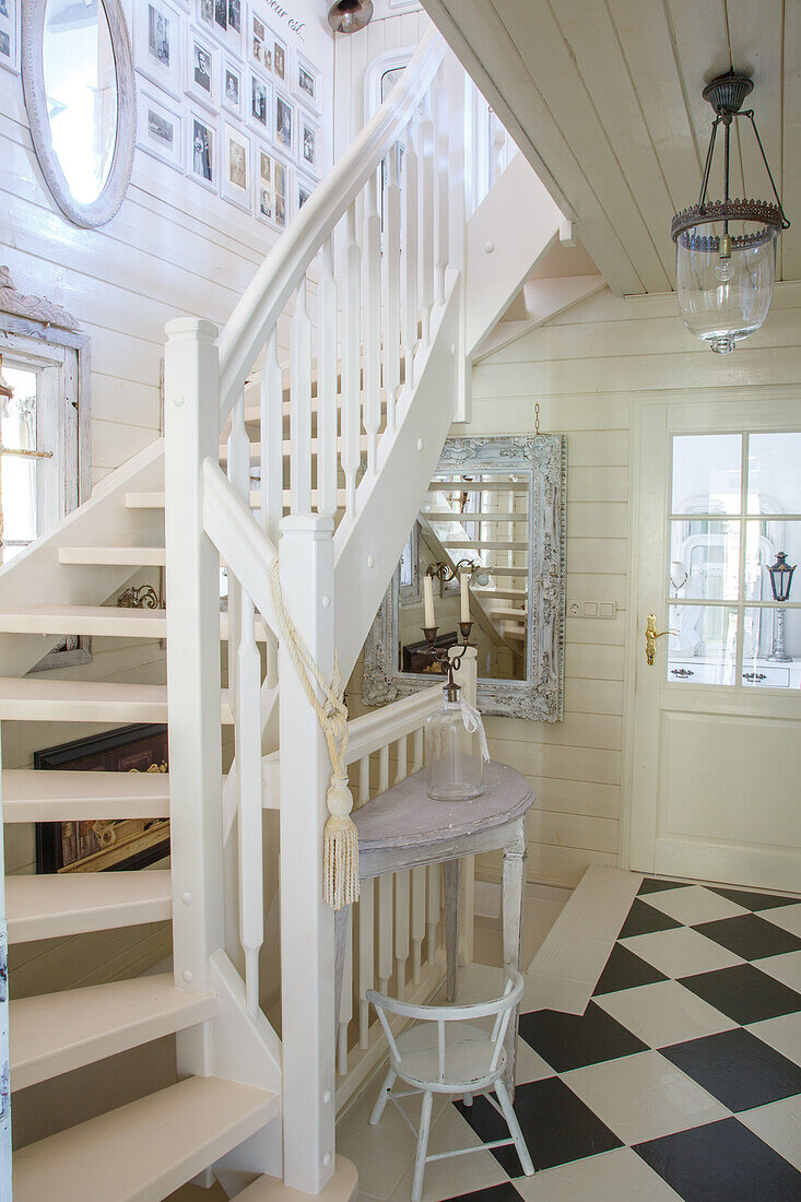 Staircase with white banister in rustic entrance area