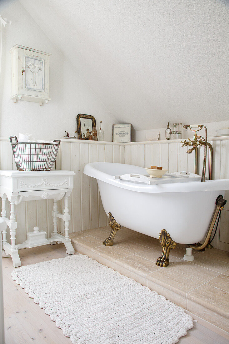 Freistehende Vintage-Badewanne mit goldenen Löwenfüßen in weiß gestaltetem Badezimmer