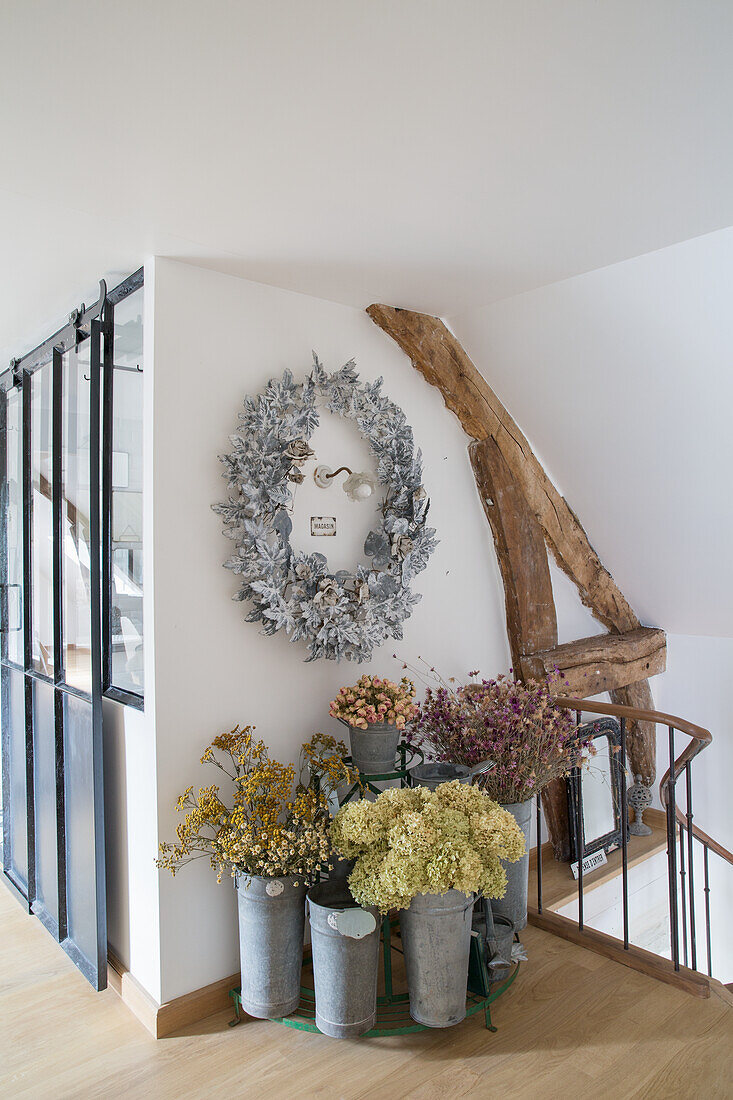 Decorative dried flower arrangement and wreath in staircase with wooden beams