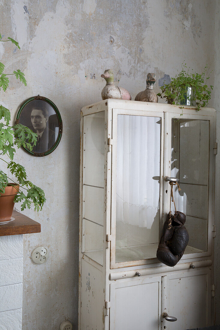 Vintage display cabinet with decorative figurines and mural