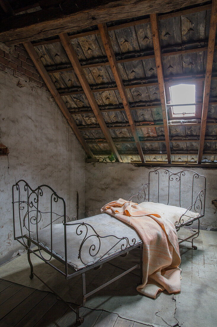 Metal bed frame with fabric blanket in rustic loft