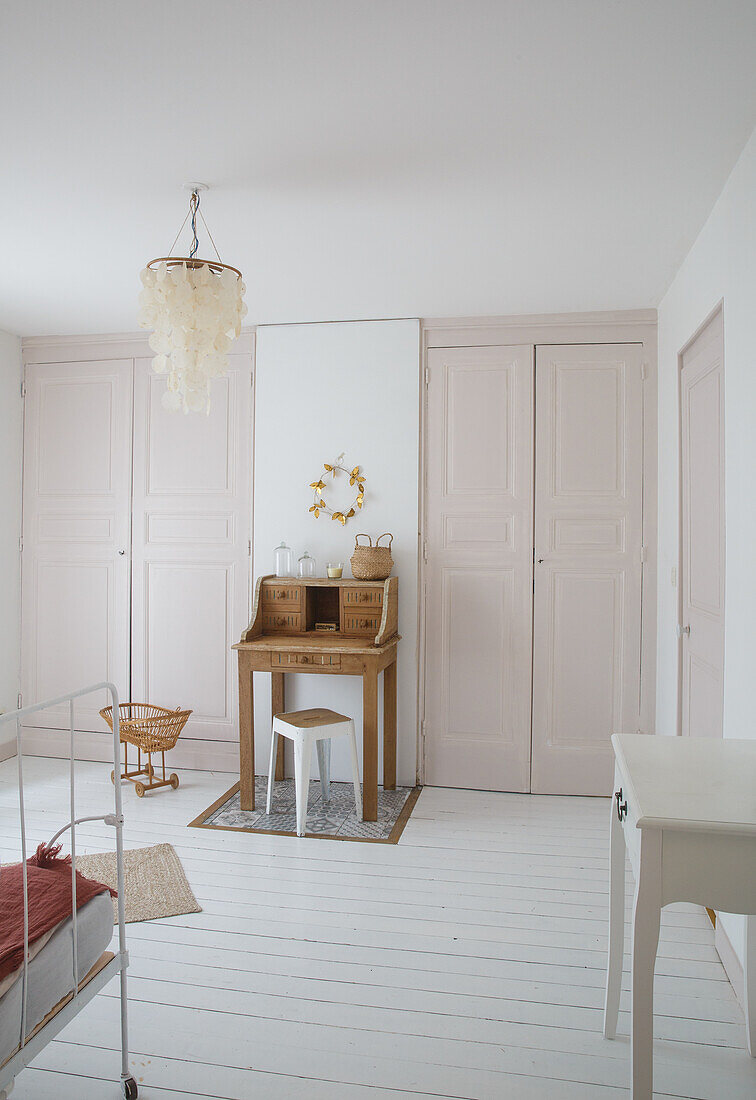 Room with pink wardrobe doors, secretary and white wooden floor