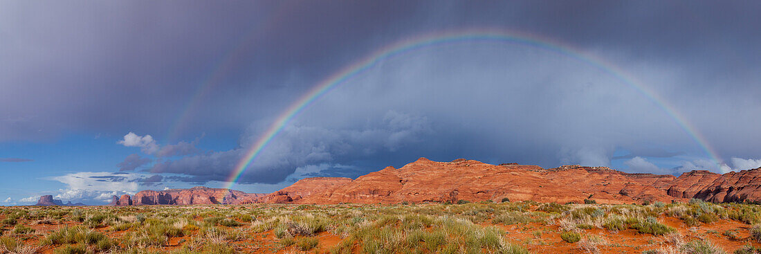 Stürmischer Himmel und ein Regenbogen im Mystery Valley im Monument Valley Navajo Tribal Park in Arizona