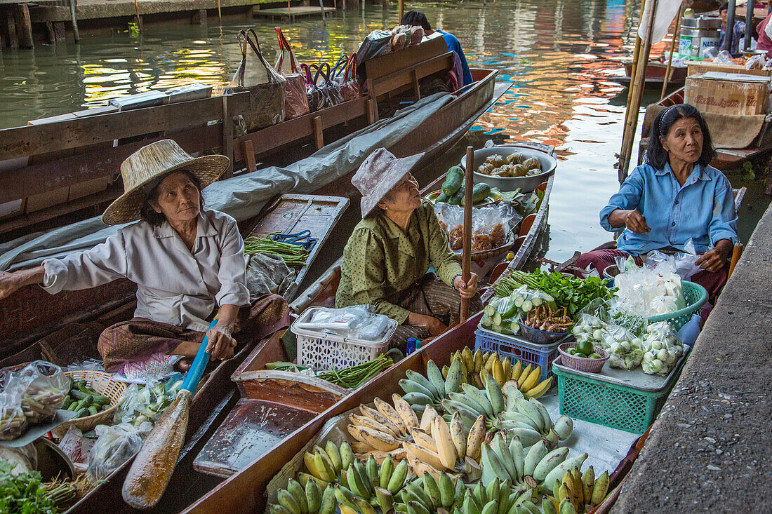 Social interaction between Thai vendors on their boats in the Damnoen Saduak Floating Market in Thailand.